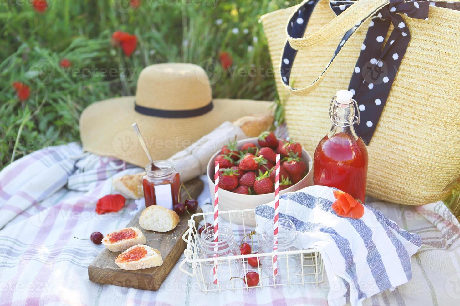 Basket, sandwiches, plaid and juice in a poppy field. photo