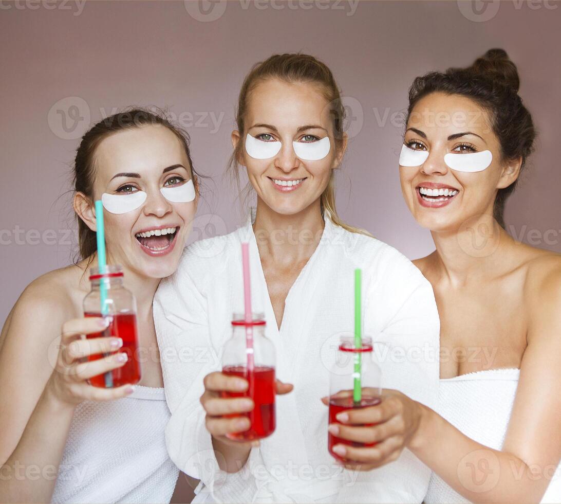 Young happy female friends drinking juice in spa photo