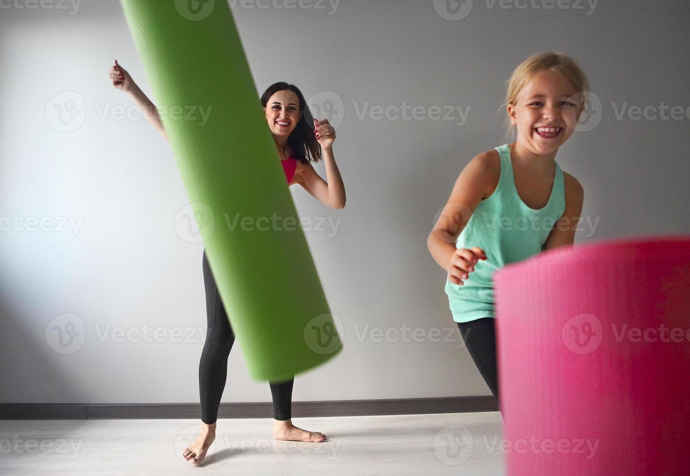 Young woman having fun with kid after yoga photo
