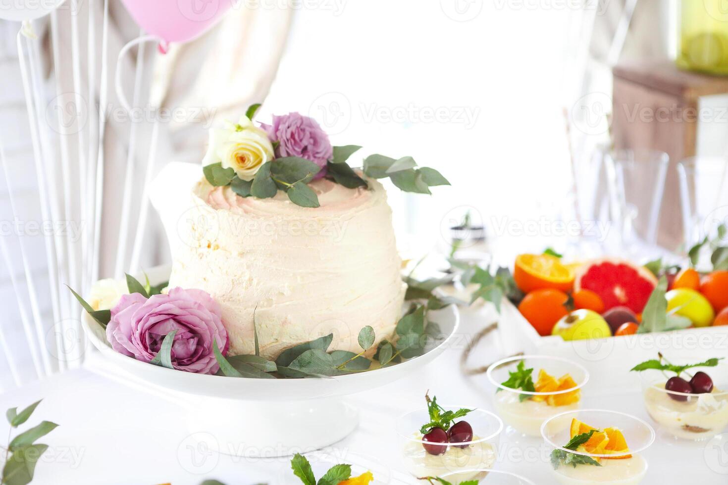 Holiday cake on table with fruits and flowers photo