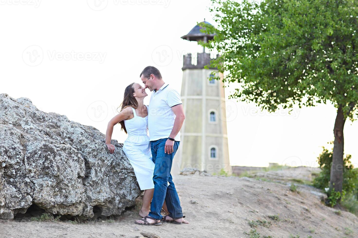 Happy couple posing on a summer day under a tree photo