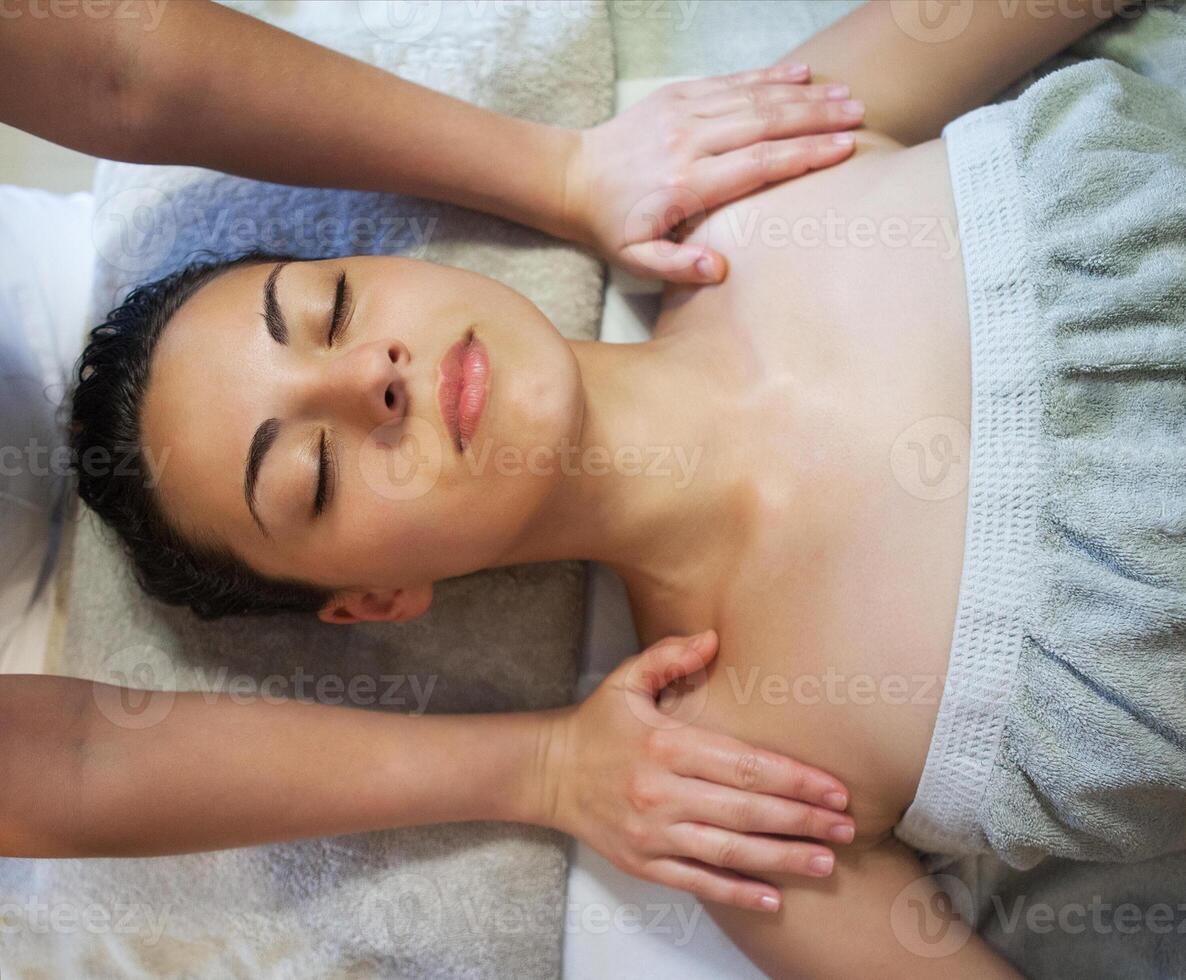 Masseur doing facial massage of an adult woman photo