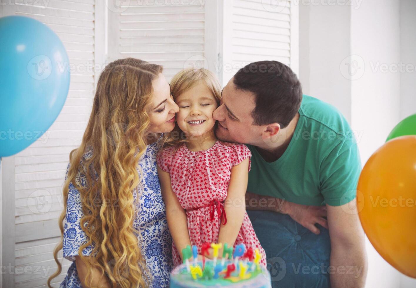 Portrait of a family celebrating birthday of their little daughter photo