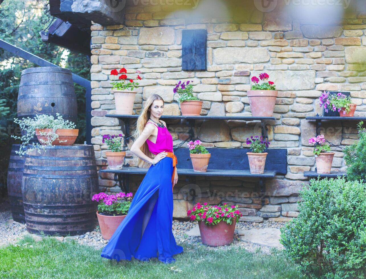 Beautiful blond woman in long colorful dress photo