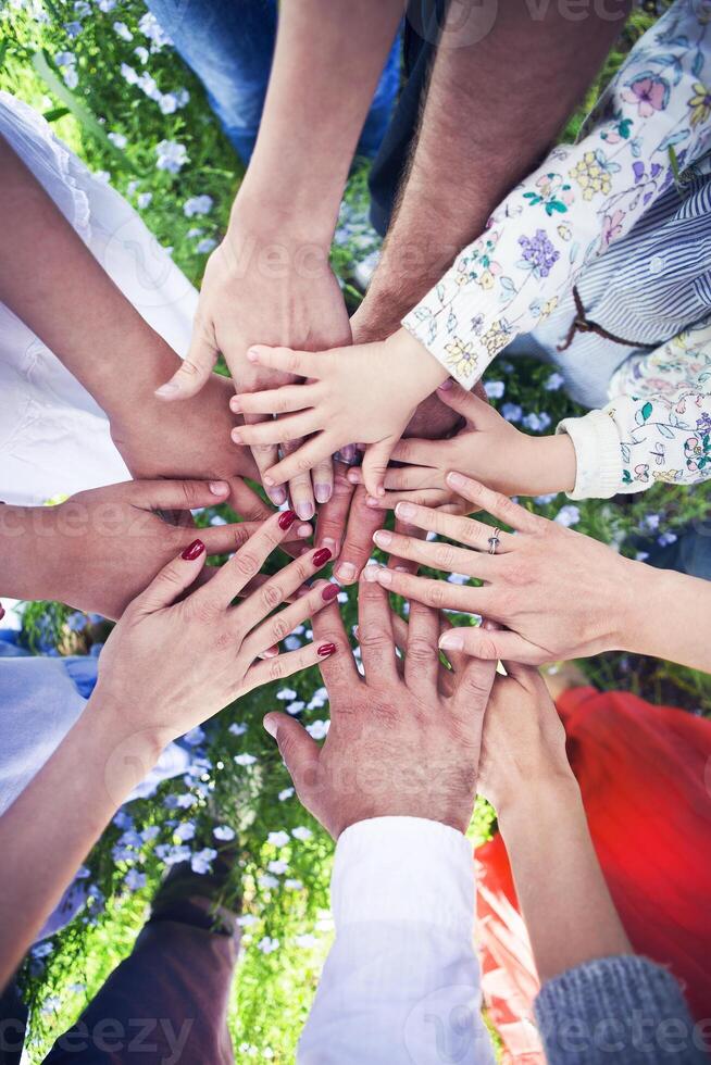 Group of friends with their hands in a complete circle photo