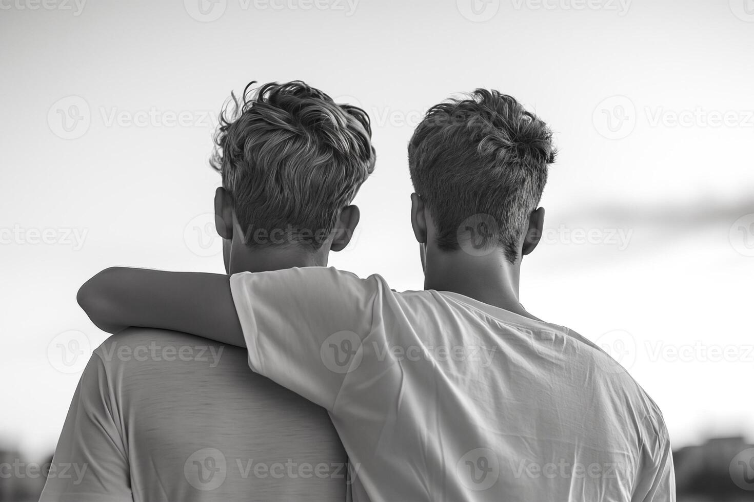 close up from the back, a black and white portrait of two men, one of whom hugs the others shoulder. concept of brother or friend, emotional support between men or gay couple photo