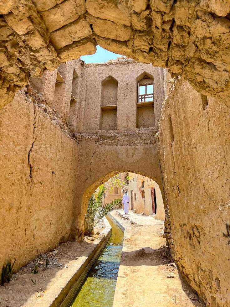 Irrigation system aflaj in a ruined village Birkat Al Mouz, Oman photo