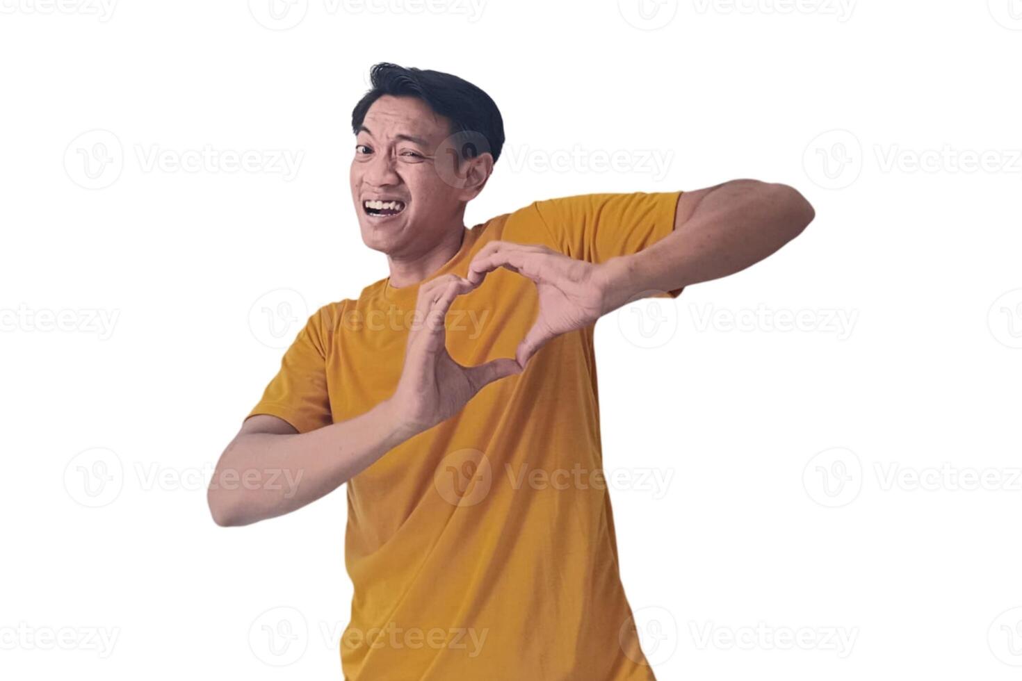 Handsome asian man with smiling in love doing heart symbol shape with hands. romantic concept.Indonesian man with love emoji. young Asian man feels happy and romantic shapes heart gesture expresses. photo