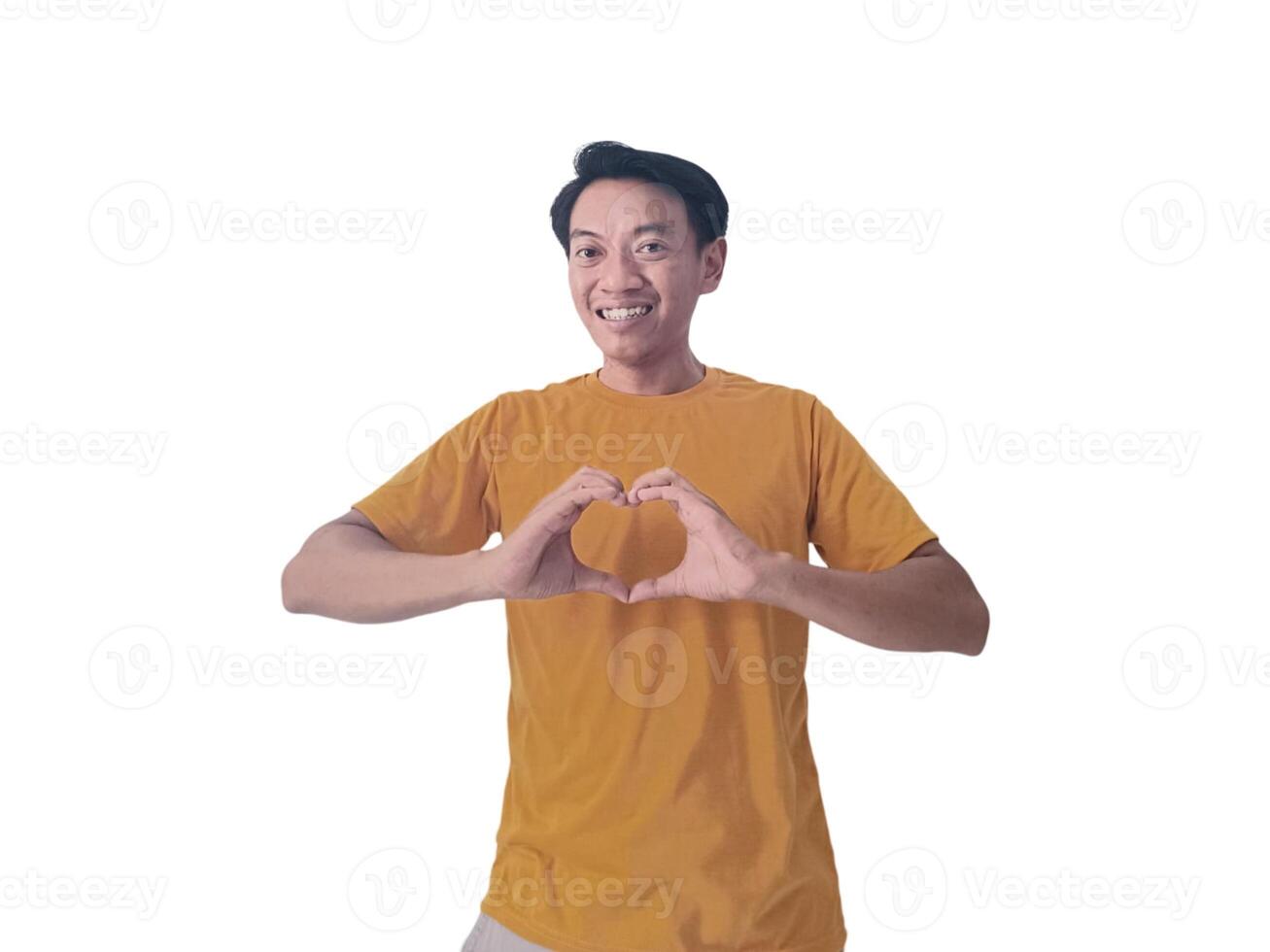 Handsome asian man with smiling in love doing heart symbol shape with hands. romantic concept.Indonesian man with love emoji. young Asian man feels happy and romantic shapes heart gesture expresses. photo