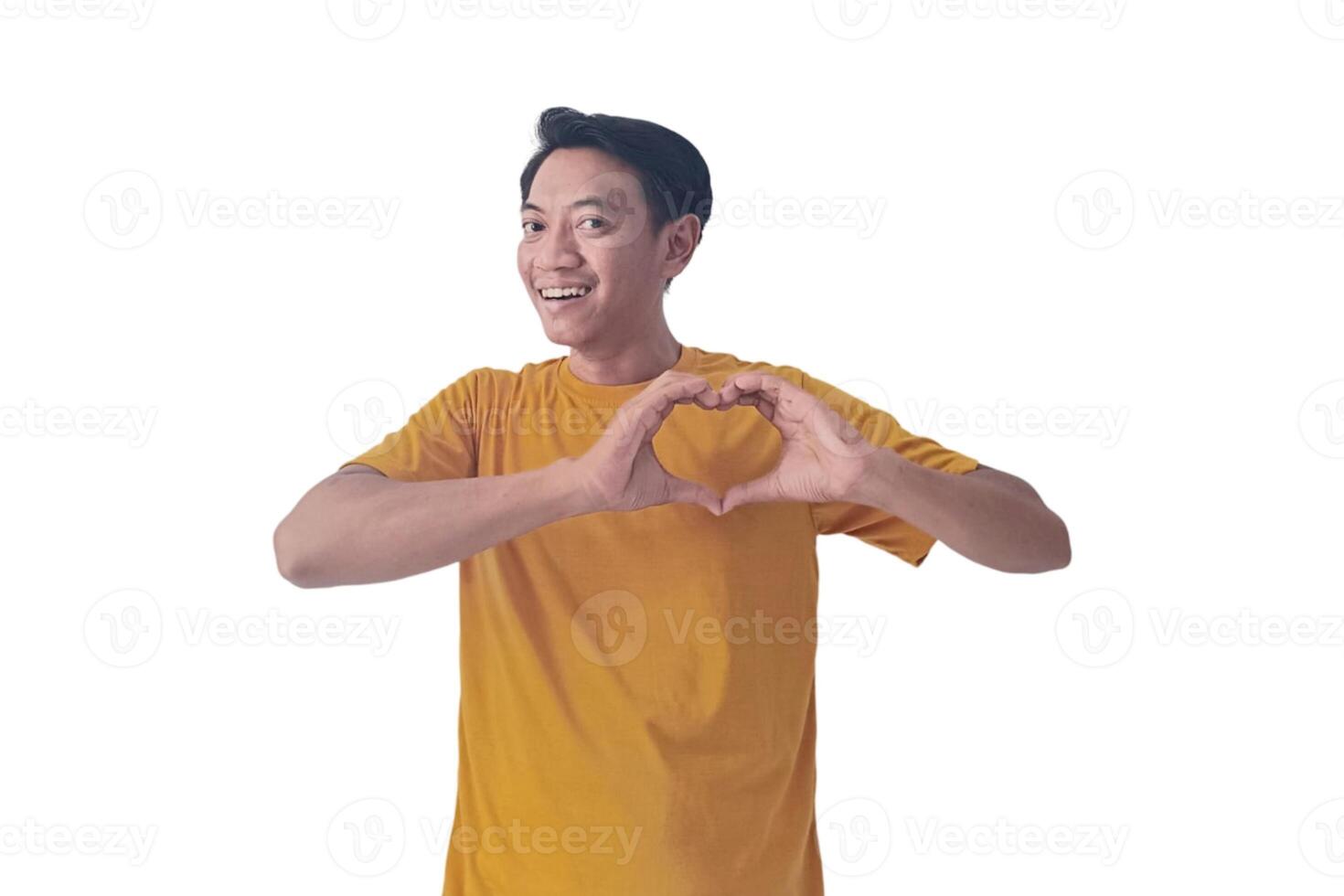 Handsome asian man with smiling in love doing heart symbol shape with hands. romantic concept.Indonesian man with love emoji. young Asian man feels happy and romantic shapes heart gesture expresses. photo