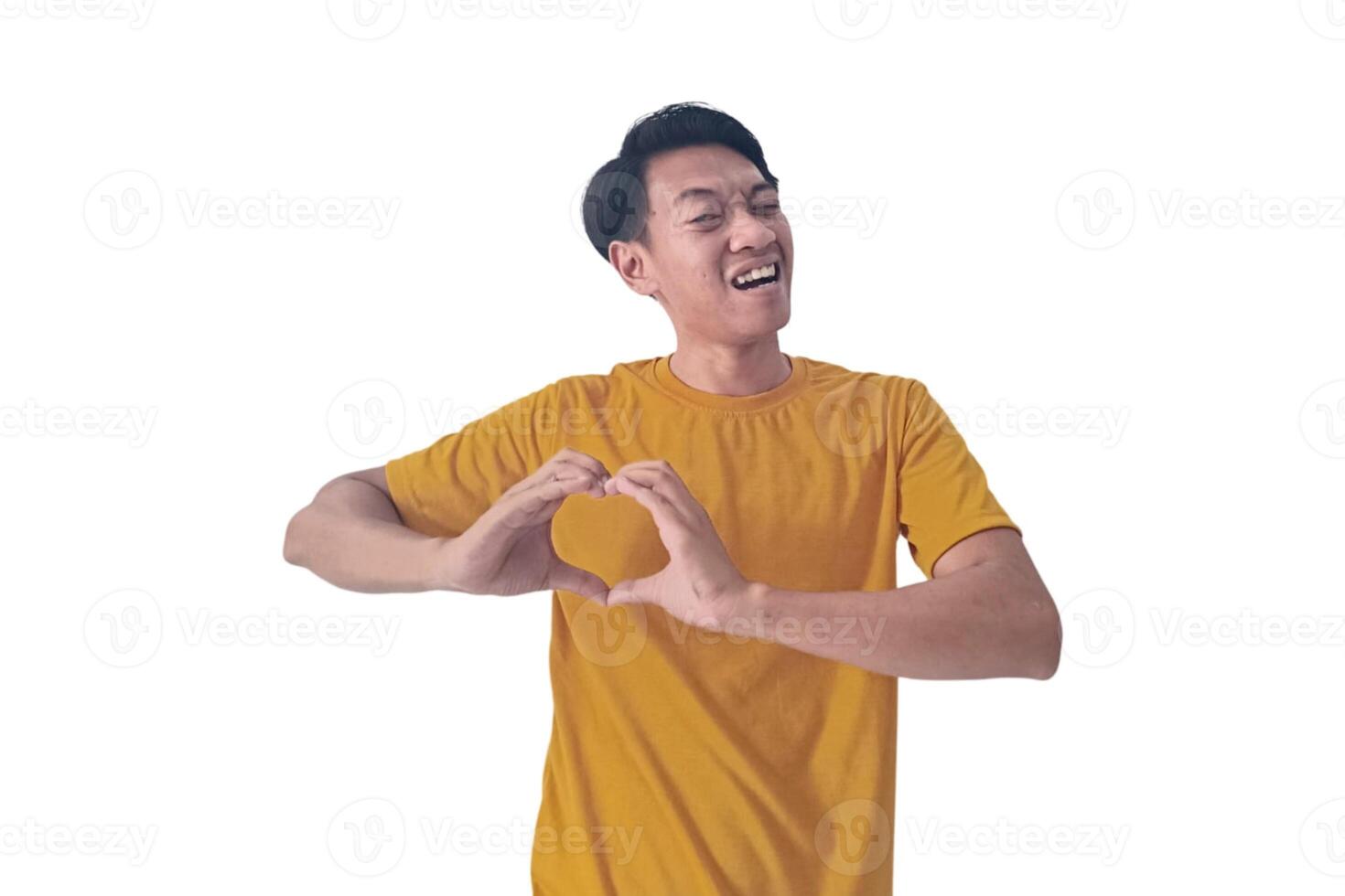 Handsome asian man with smiling in love doing heart symbol shape with hands. romantic concept.Indonesian man with love emoji. young Asian man feels happy and romantic shapes heart gesture expresses. photo