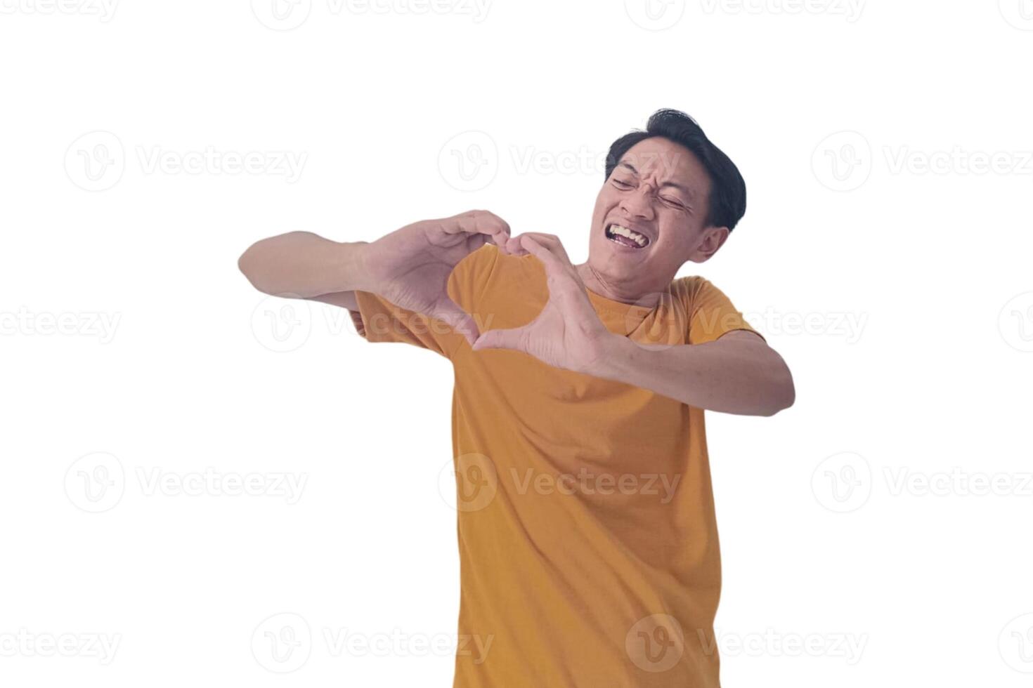 Handsome asian man with smiling in love doing heart symbol shape with hands. romantic concept.Indonesian man with love emoji. young Asian man feels happy and romantic shapes heart gesture expresses. photo