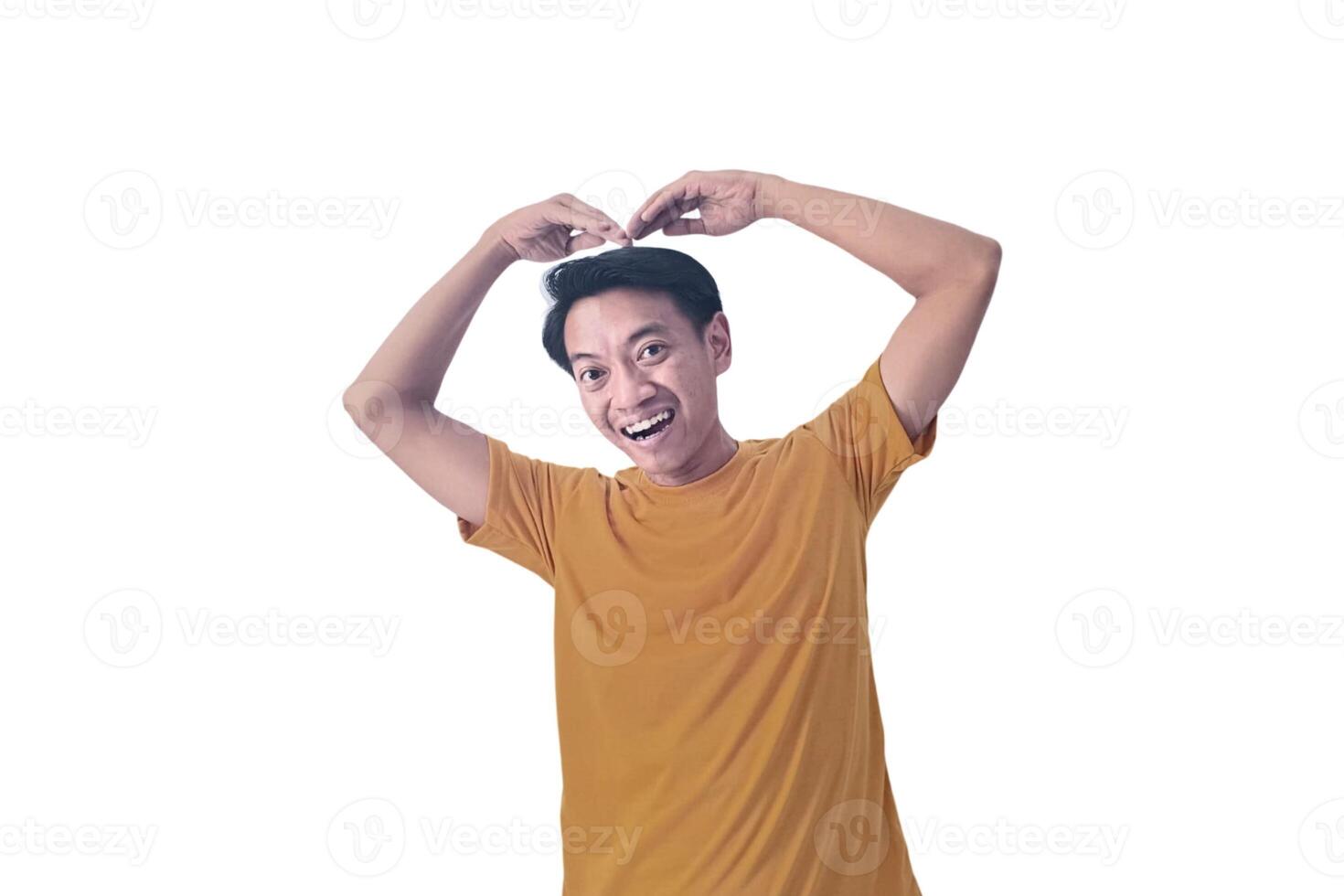 Handsome asian man with smiling in love doing heart symbol shape with hands. romantic concept.Indonesian man with love emoji. young Asian man feels happy and romantic shapes heart gesture expresses. photo