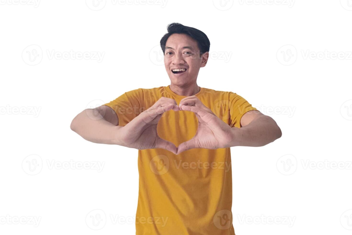 Handsome asian man with smiling in love doing heart symbol shape with hands. romantic concept.Indonesian man with love emoji. young Asian man feels happy and romantic shapes heart gesture expresses. photo