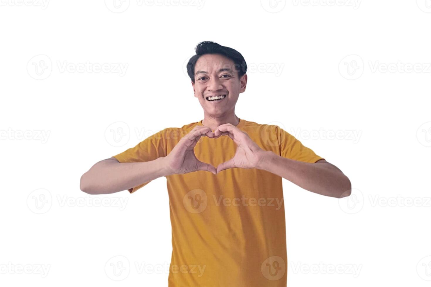 Handsome asian man with smiling in love doing heart symbol shape with hands. romantic concept.Indonesian man with love emoji. young Asian man feels happy and romantic shapes heart gesture expresses. photo