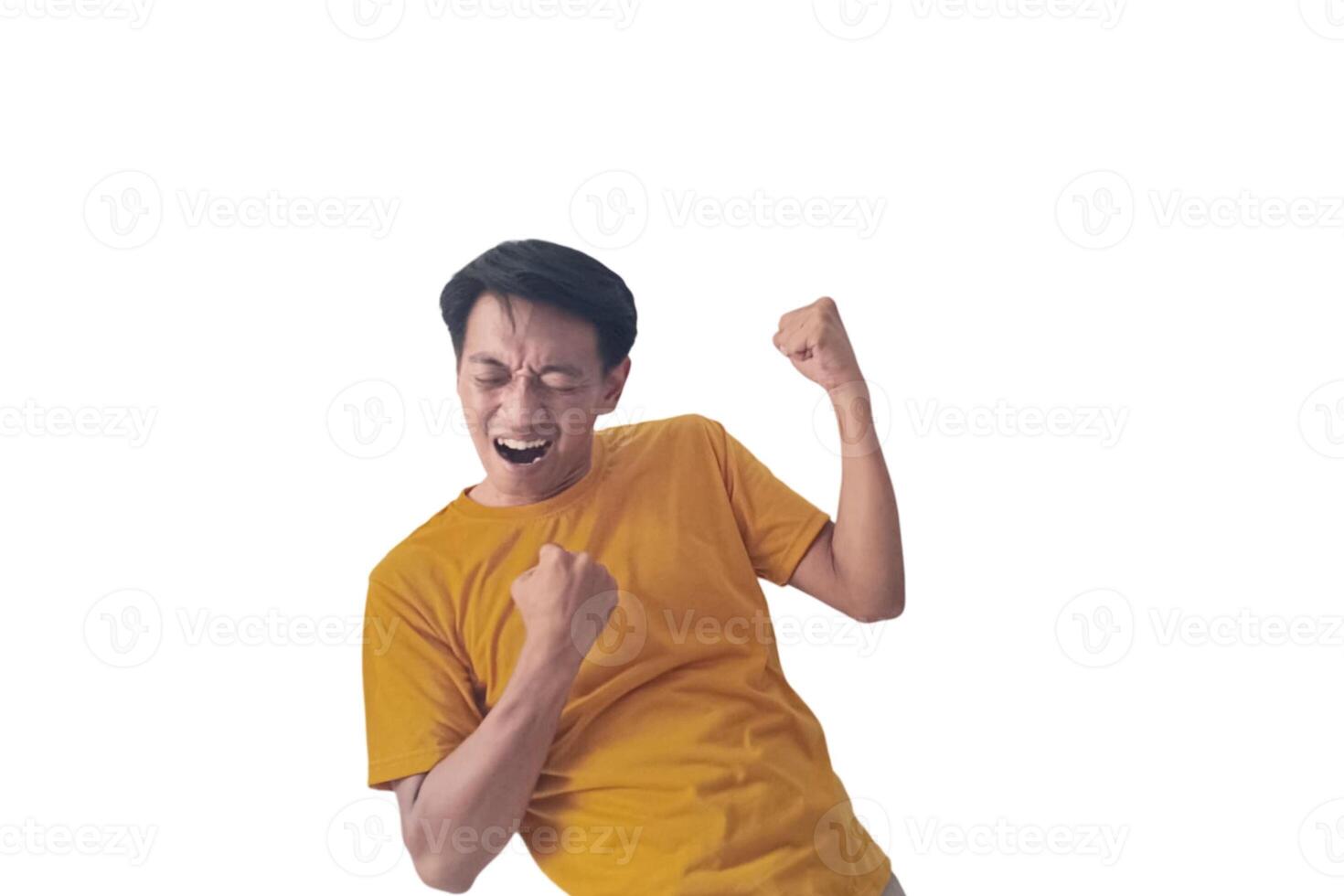 Handsome Asian man in a orange shirt raises both fists in a celebratory gesture, his face beaming with excitement and on white background emphasizes his triumphant and enthusiastic expression. photo
