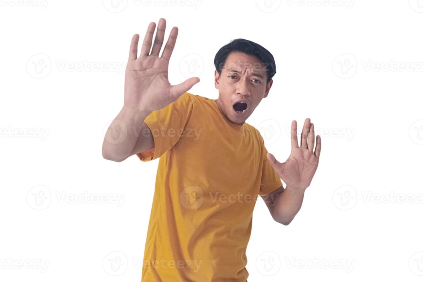 Portrait of an Asian man wearing a orange T-shirt, expressing surprise and shock with open palms, isolated against a white background. photo