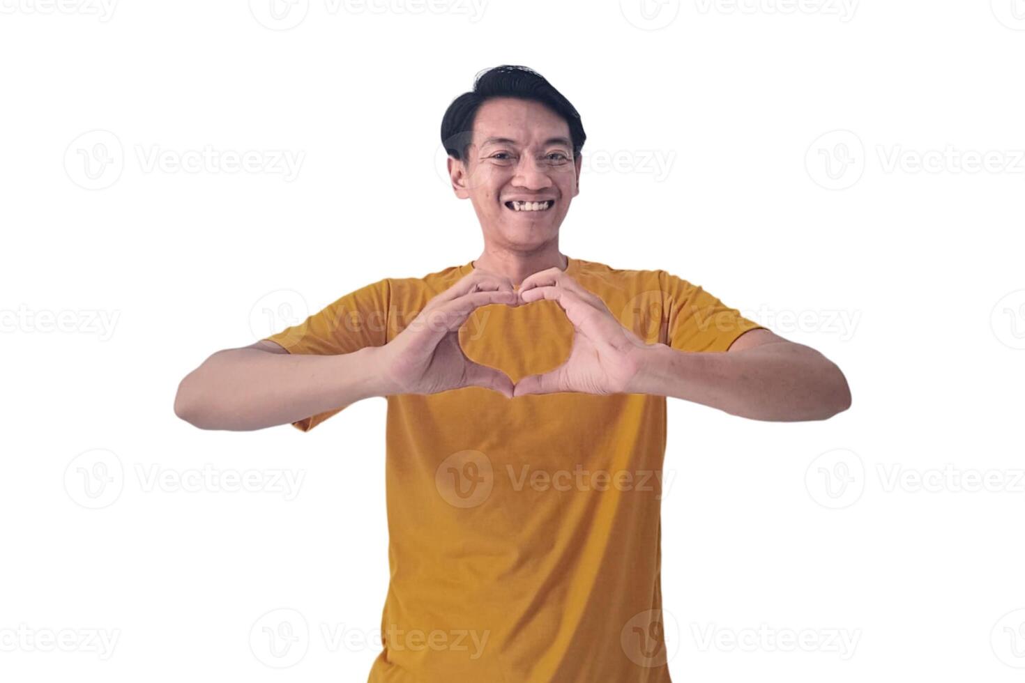 Handsome asian man with smiling in love doing heart symbol shape with hands. romantic concept.Indonesian man with love emoji. young Asian man feels happy and romantic shapes heart gesture expresses. photo