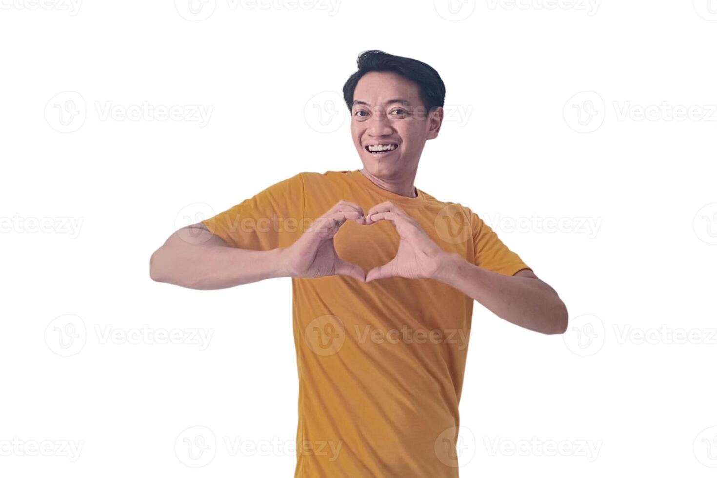 Handsome asian man with smiling in love doing heart symbol shape with hands. romantic concept.Indonesian man with love emoji. young Asian man feels happy and romantic shapes heart gesture expresses. photo