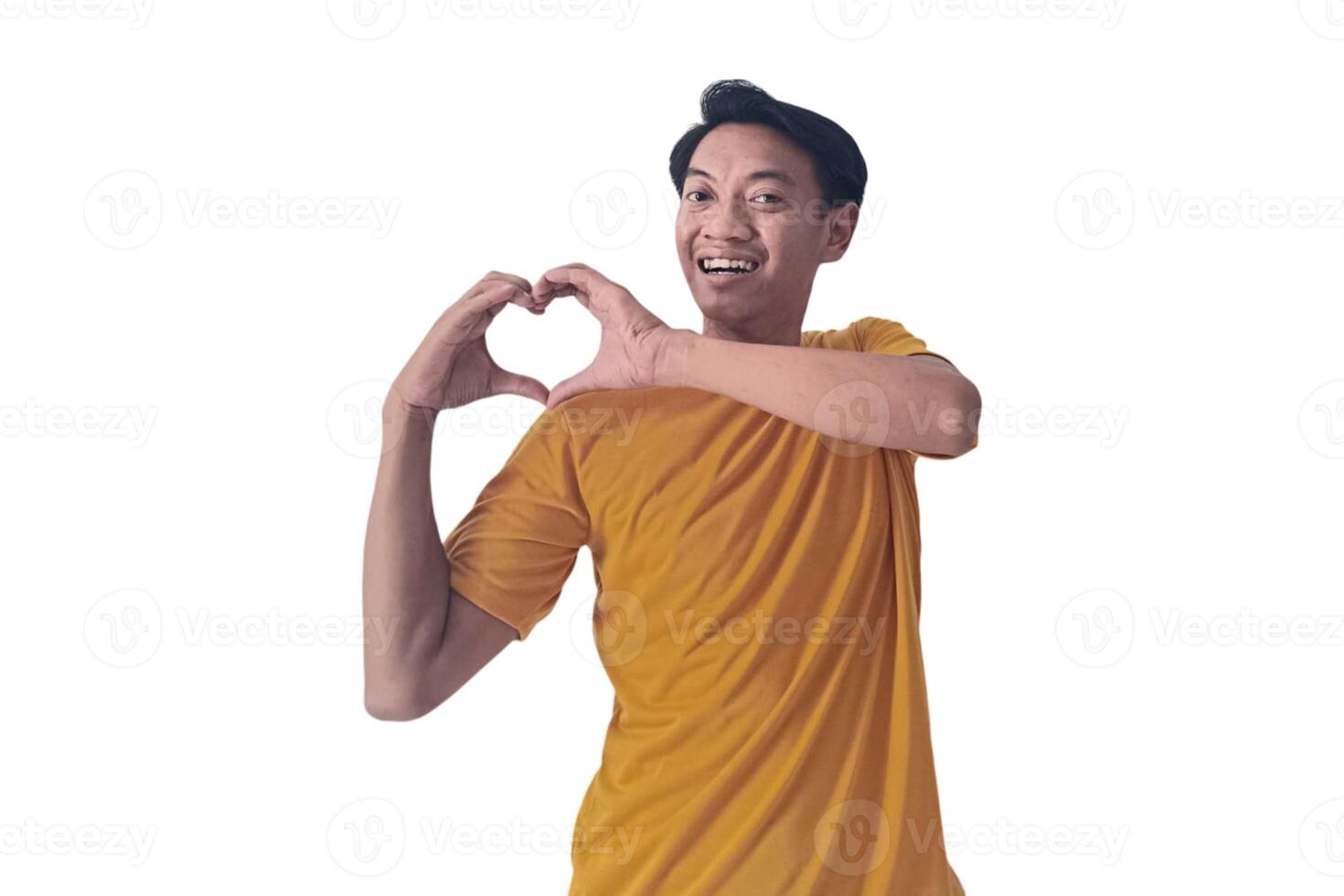 Handsome asian man with smiling in love doing heart symbol shape with hands. romantic concept.Indonesian man with love emoji. young Asian man feels happy and romantic shapes heart gesture expresses. photo