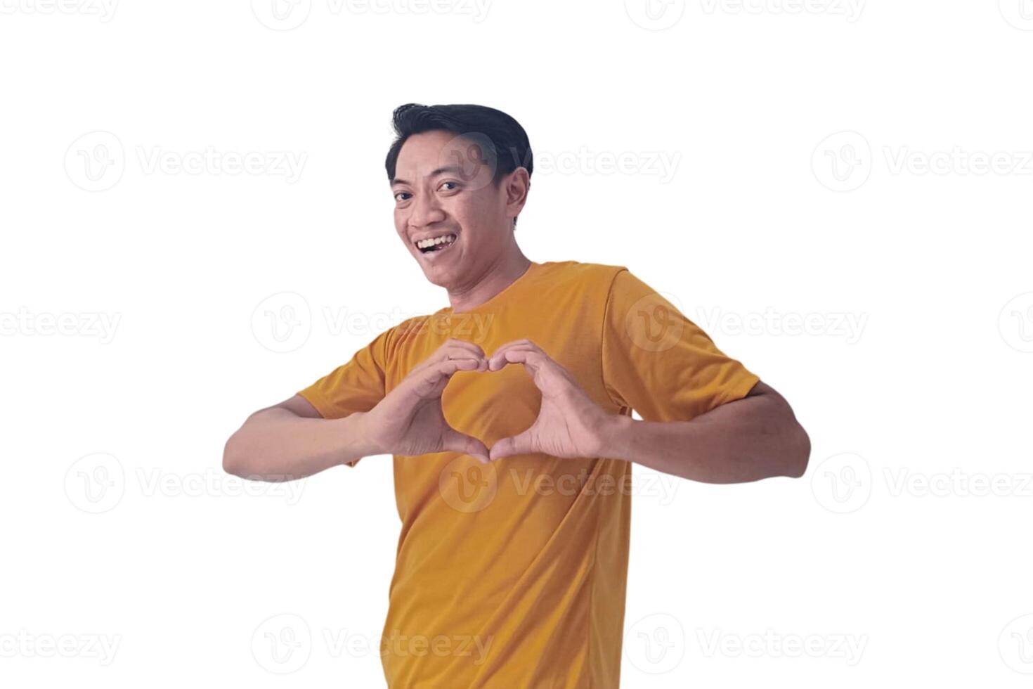 Handsome asian man with smiling in love doing heart symbol shape with hands. romantic concept.Indonesian man with love emoji. young Asian man feels happy and romantic shapes heart gesture expresses. photo