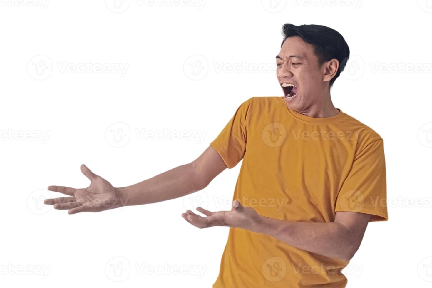 Portrait of an Asian man wearing a orange T-shirt, expressing surprise and shock with open palms, isolated against a white background. photo