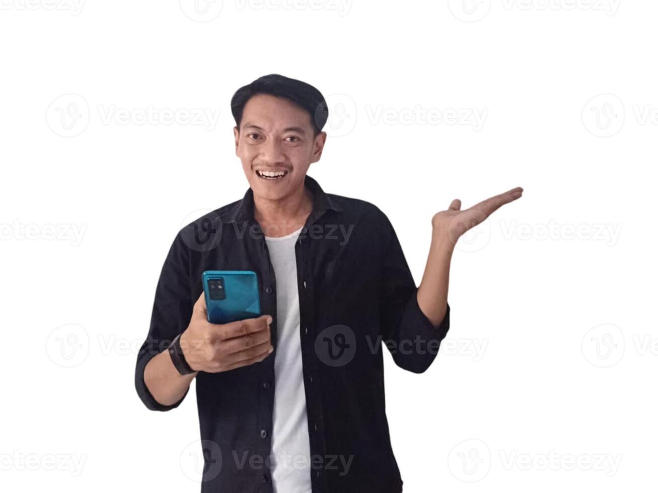 Young asian man holding mobile phone surprised in casual shirt showing copy space on palm isolated on white background. Good offer concept photo