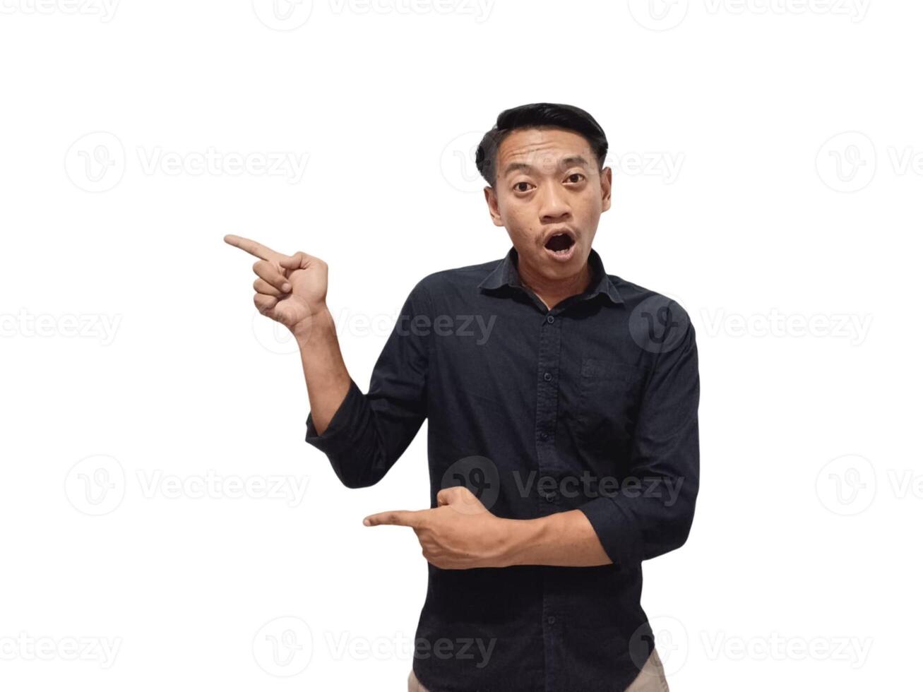 Shocked young Asian man in casual shirt pointing finger aside at copy space isolated on white background. Great offer concept photo