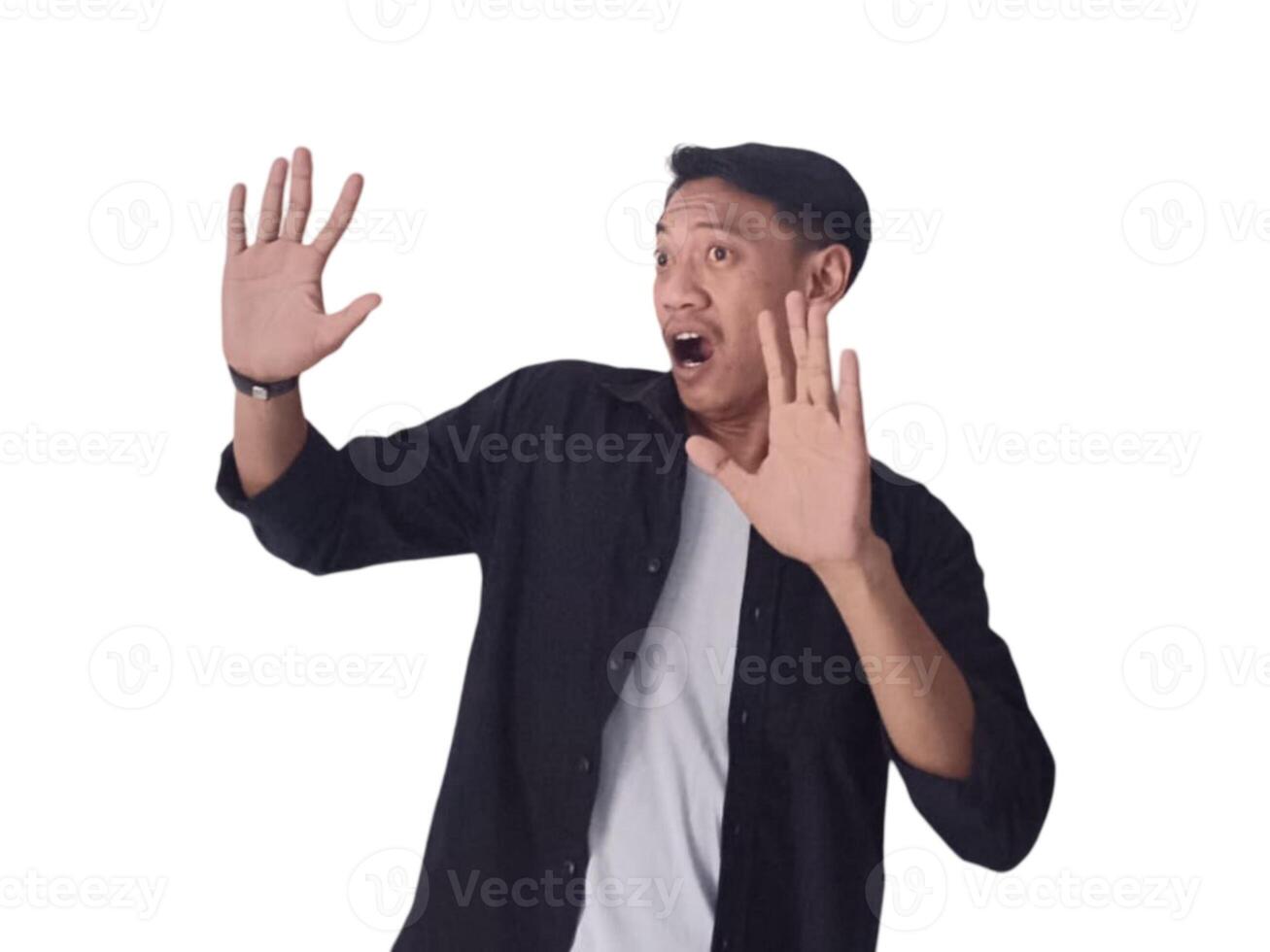 Surprised young handsome Asian man looking upward with raised hands isolated on white background photo