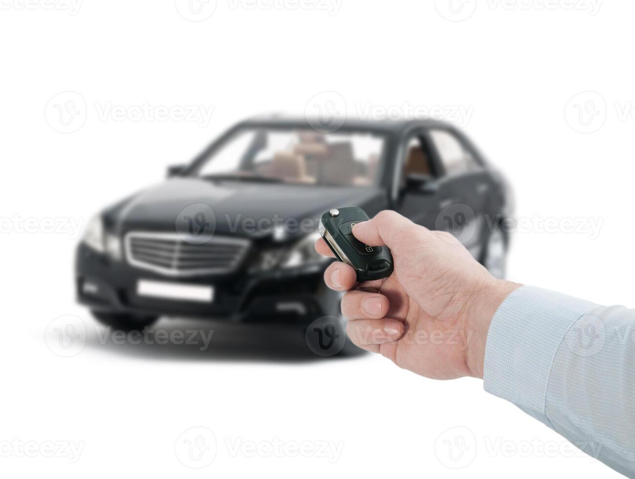 A person holding a remote control in front of a car photo
