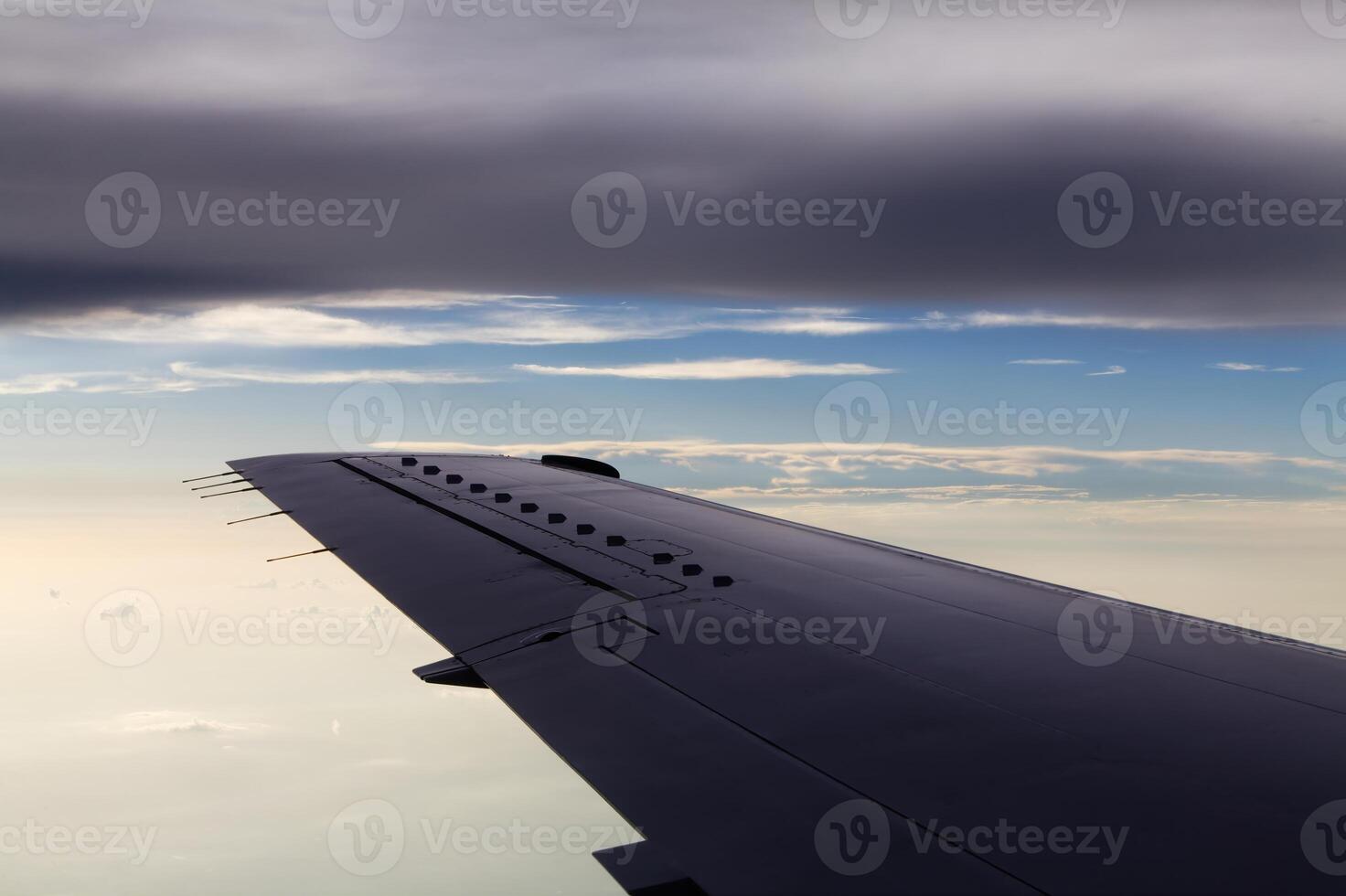 Commercial Aircraft Wing In Flight Between Two Layers Of Clouds photo