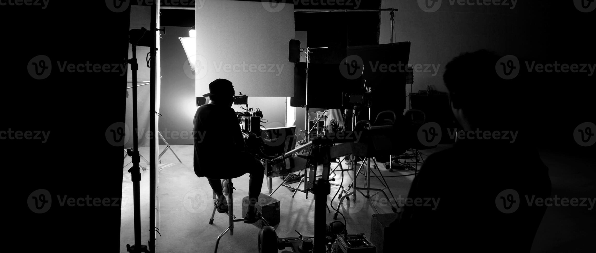 Silhouette of film crews and camera on special dolly crane with film lights and set. photo