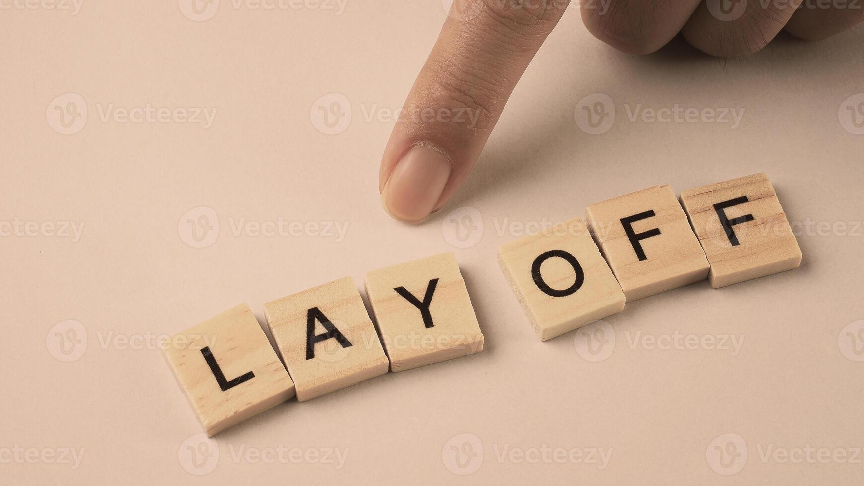 Word of Lay Off. Text written by wood toy or wood cubes on white paper background photo