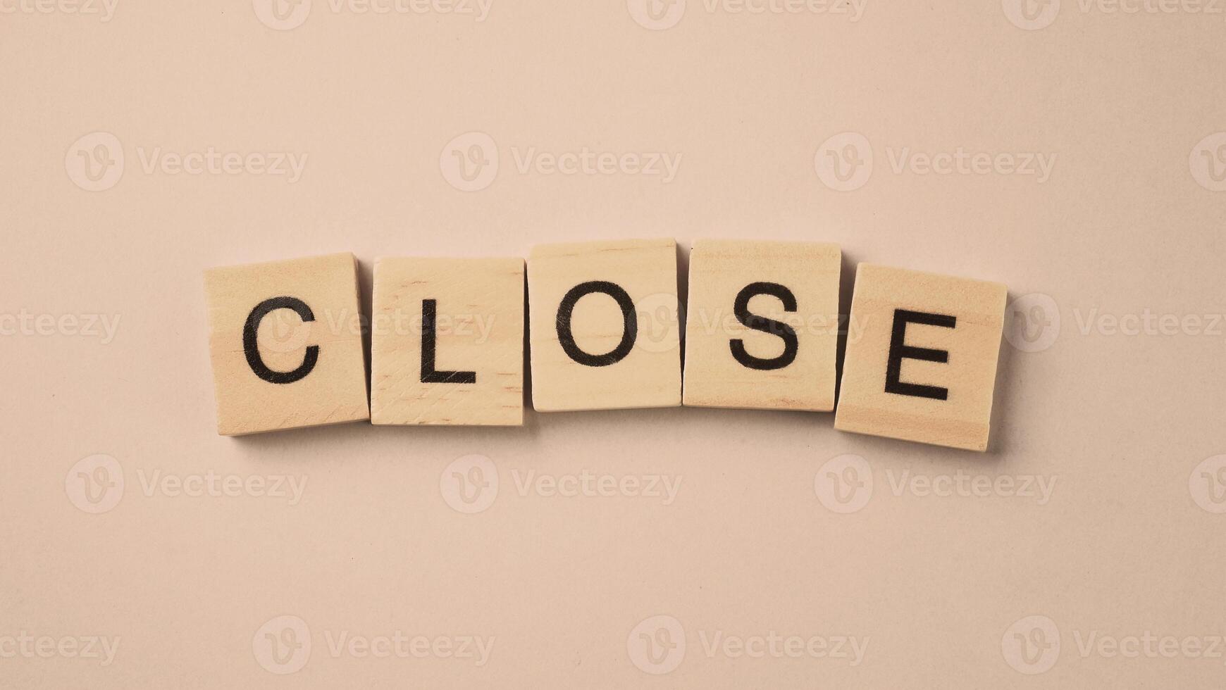 Word of Close. Text written by wood toy or wood cubes on white paper background photo