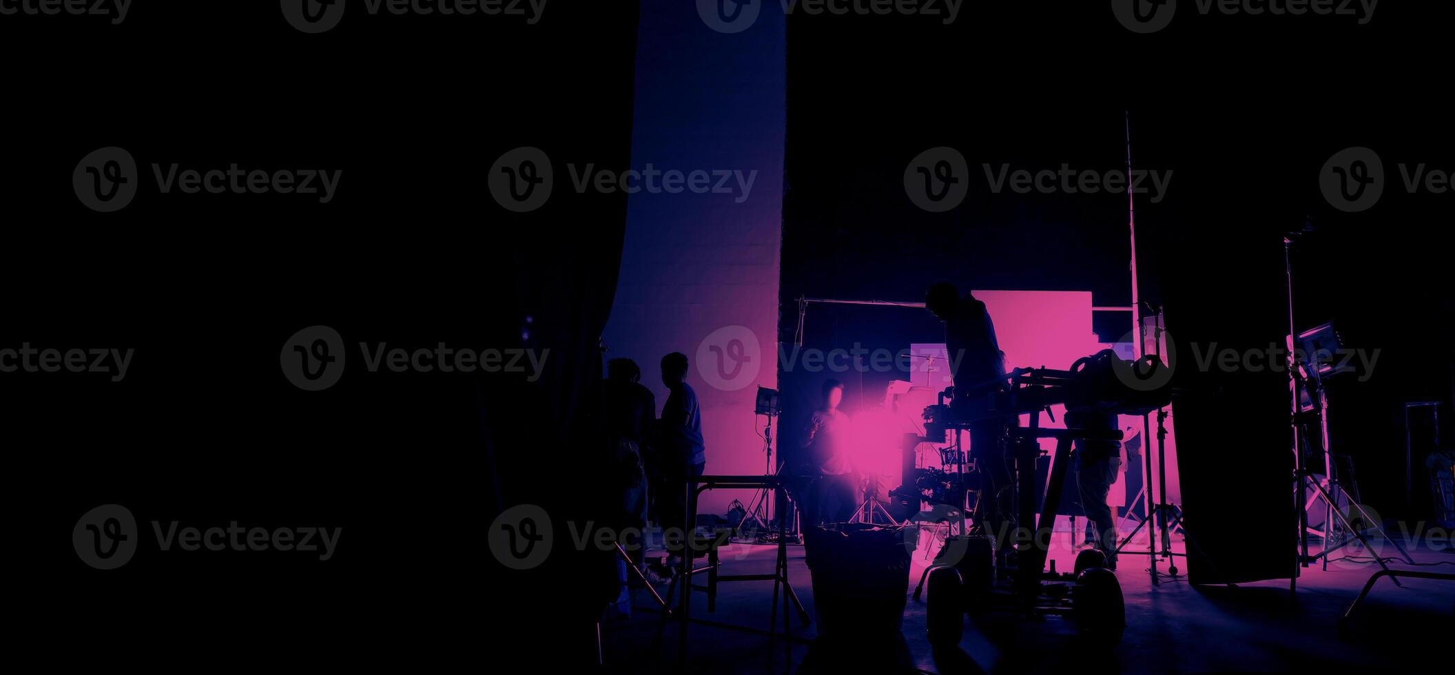 Silhouette of film crews and camera on special dolly crane with film lights and set. photo