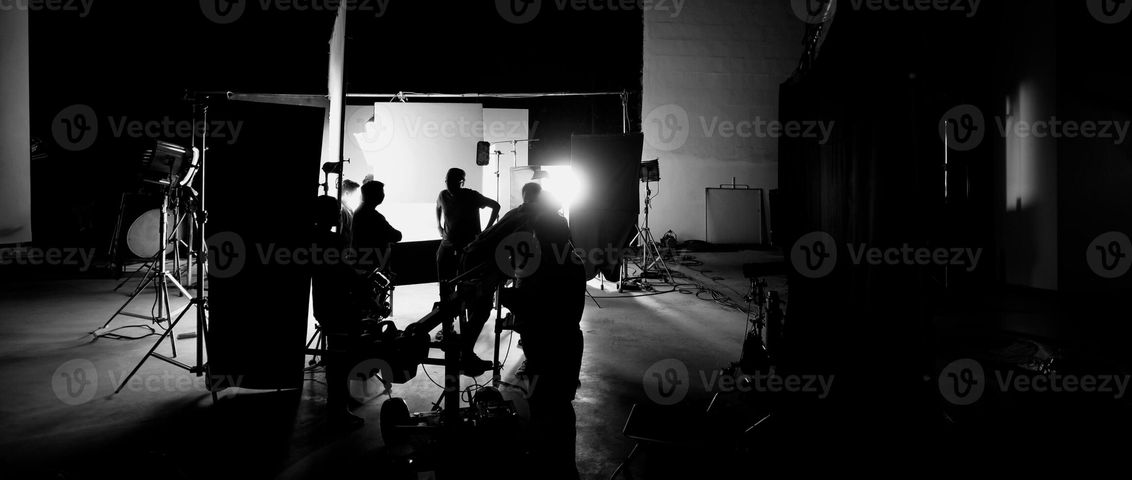 Silhouette of film crews and camera on special dolly crane with film lights and set. photo