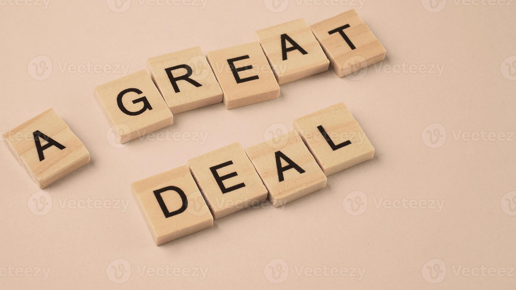 Word of A Great Deal. Text written by wood toy or wood cubes on white paper background photo