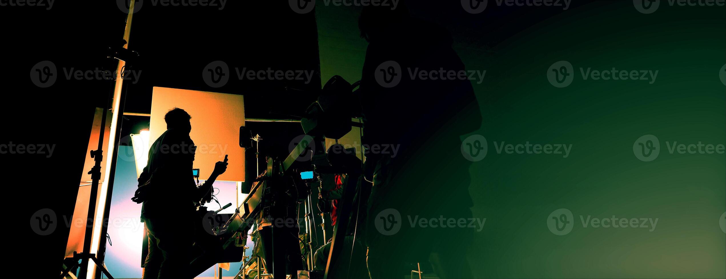 Silhouette of film crews and camera on special dolly crane with film lights and set. photo