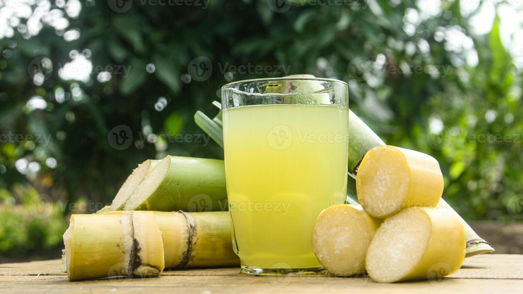 Drink from sugar cane juice, squeezed sugar cane juice with sugar cane stalks and natural background photo