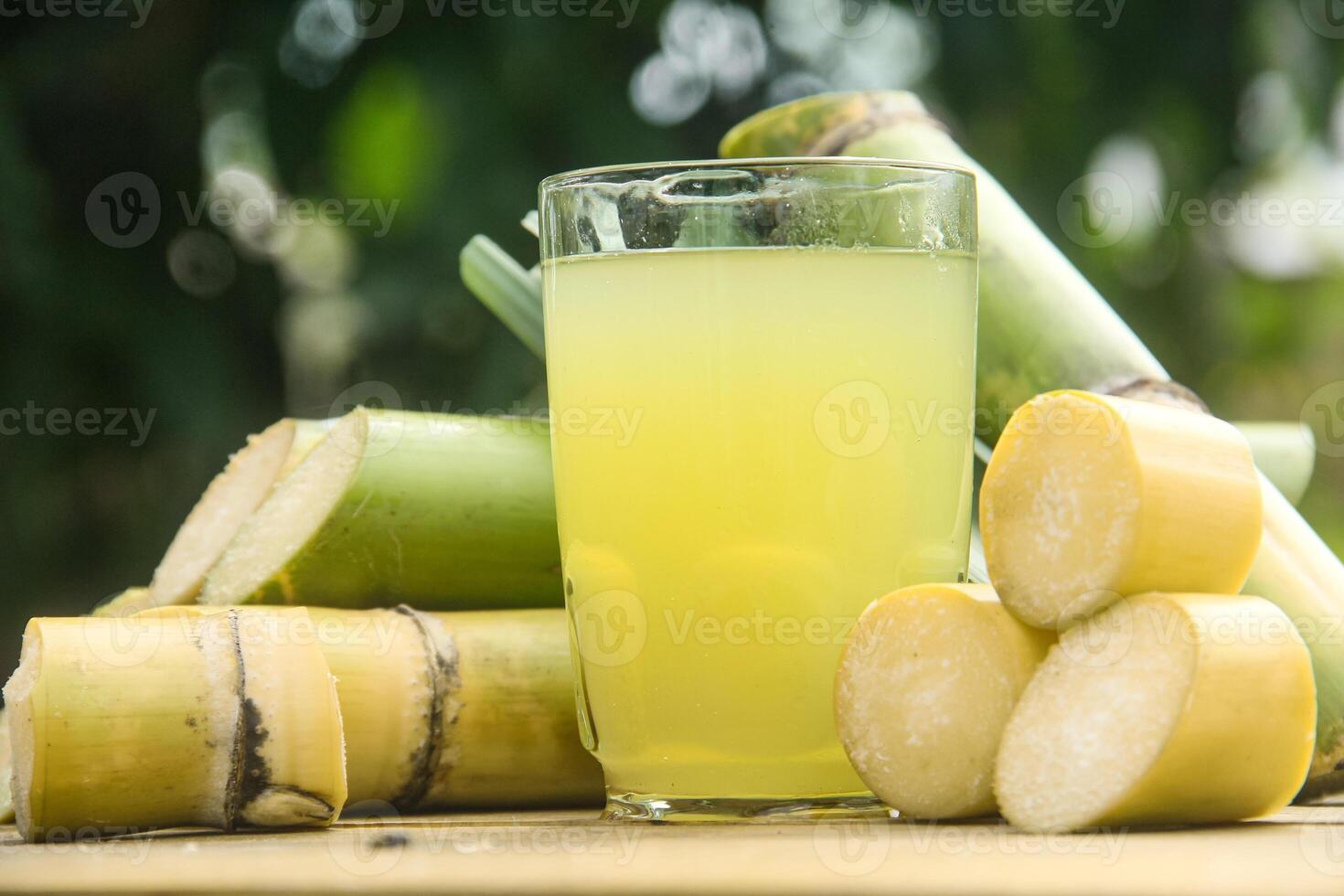 Drink from sugar cane juice, squeezed sugar cane juice with sugar cane stalks and natural background photo