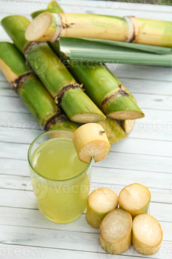 Drink from sugar cane juice, squeezed sugar cane juice with sugar cane stalks and natural background photo