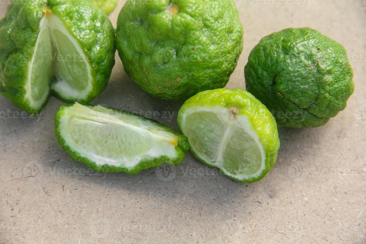 Bergamot fruits or sliced kaffir lime or Citrus hystrix on wooden table and natural green background photo