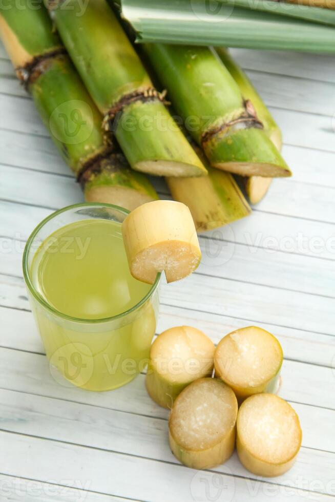 Drink from sugar cane juice, squeezed sugar cane juice with sugar cane stalks and natural background photo