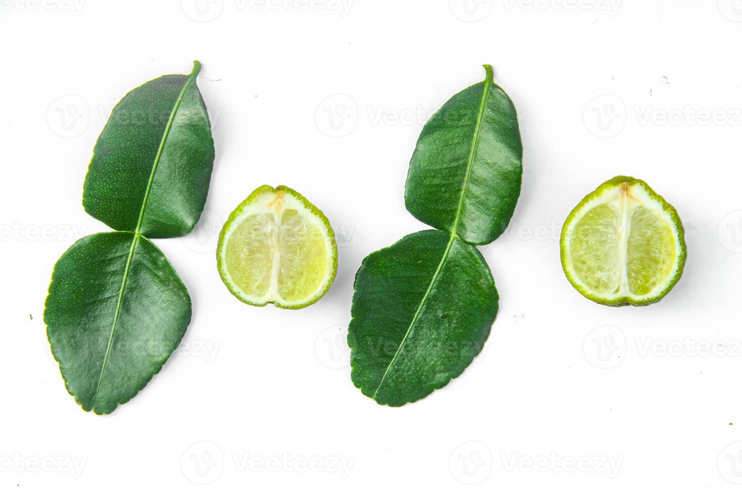 Citrus hystrix or kaffir lime or bergamot sliced fruit and its leaves isolated on white background photo