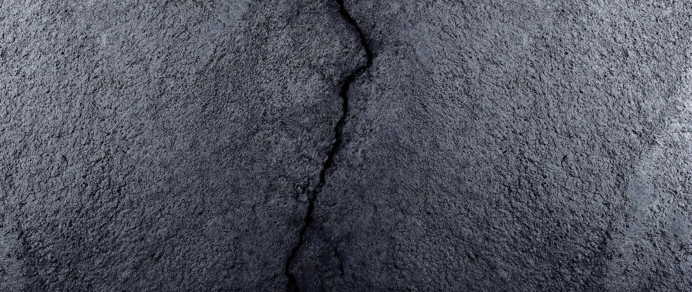 Cracked concrete wall covered with gray cement mortar, Destruction caused by an earthquake, Large uneven crack in the wall, Texture background, Repair. photo