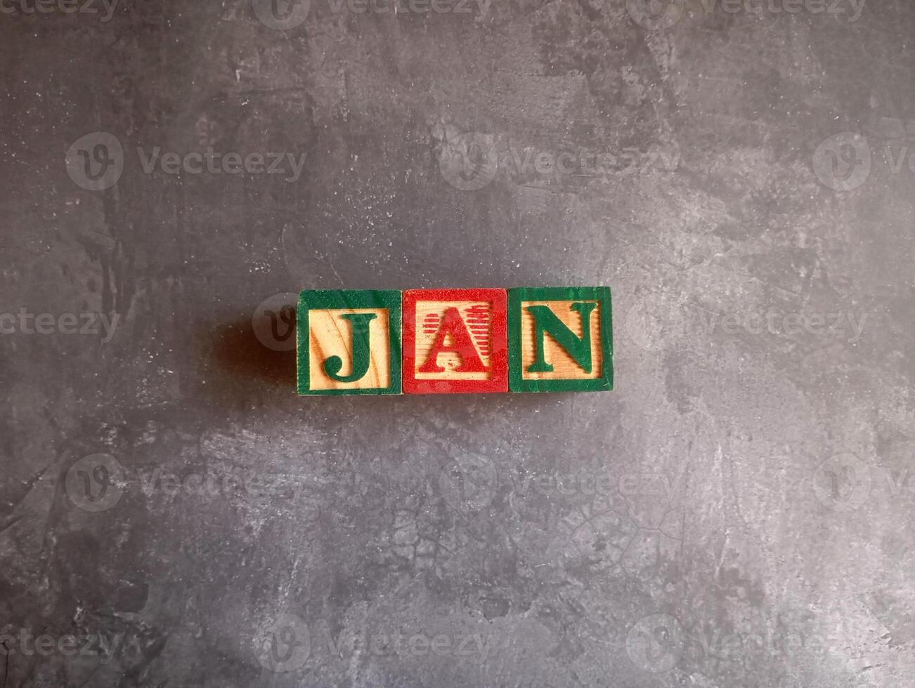 A photo of a wooden block with the words january written on it, styled in isolation with space for text.
