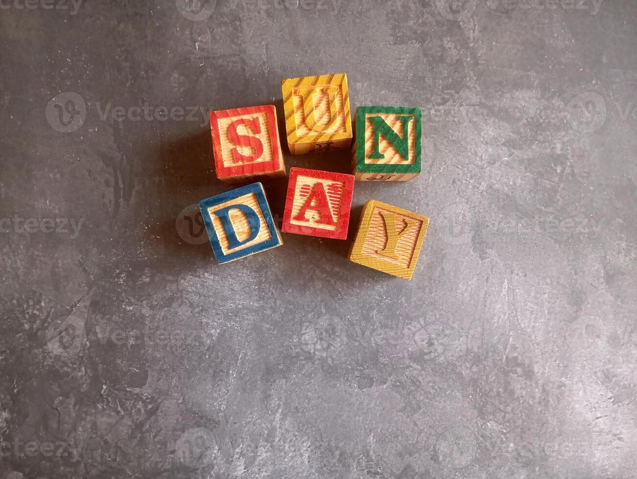 A photo of a wooden block with the words sunday written on it, styled in isolation with space for text.