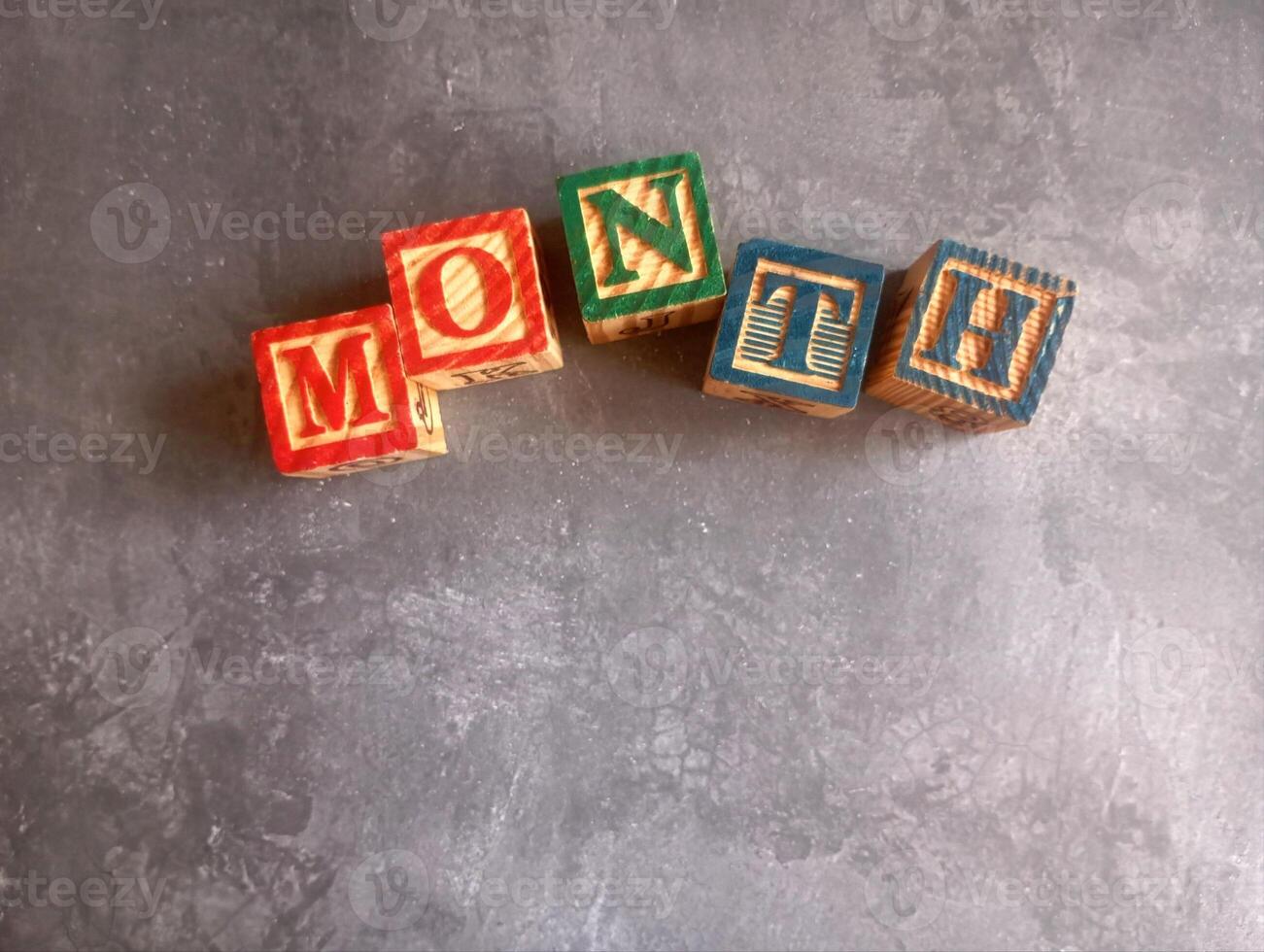A photo of a wooden block with the words month written on it, styled in isolation with space for text.