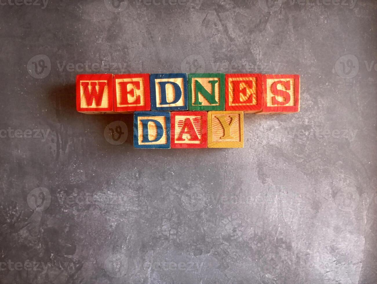 A photo of a wooden block with the words wednesday written on it, styled in isolation with space for text.