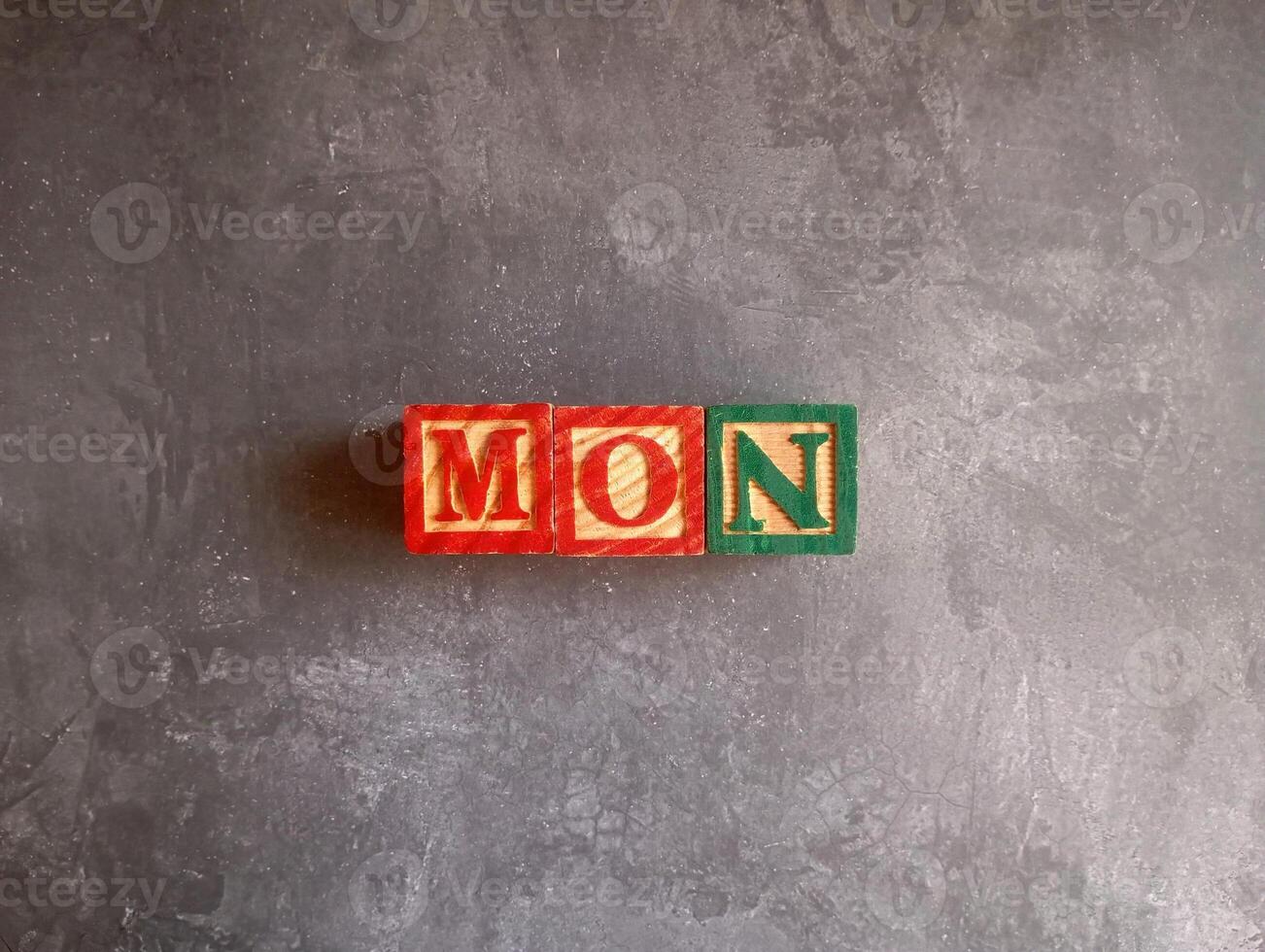 A photo of a wooden block with the words monday written on it, styled in isolation with space for text.